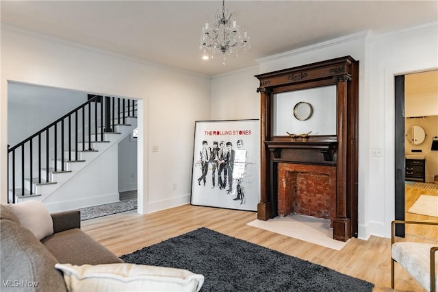 living room featuring wood-type flooring, a notable chandelier, and ornamental molding