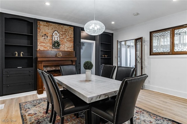 dining space featuring built in shelves, crown molding, and light wood-type flooring