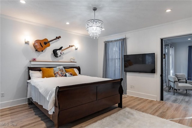 bedroom with light hardwood / wood-style floors, crown molding, and an inviting chandelier