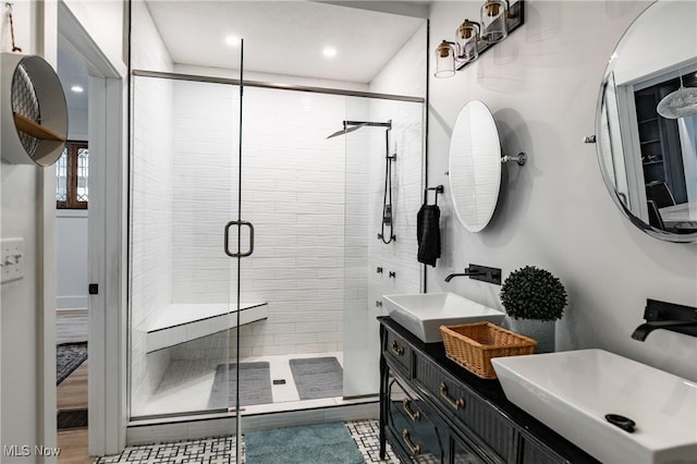 bathroom with a shower with door and vanity