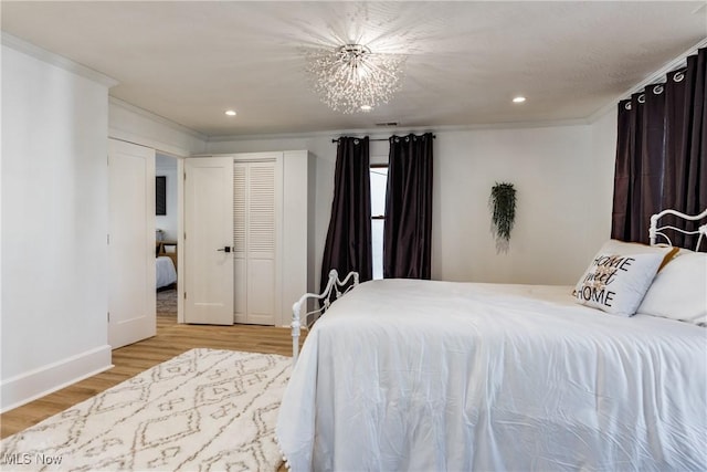 bedroom with crown molding, a chandelier, and light wood-type flooring