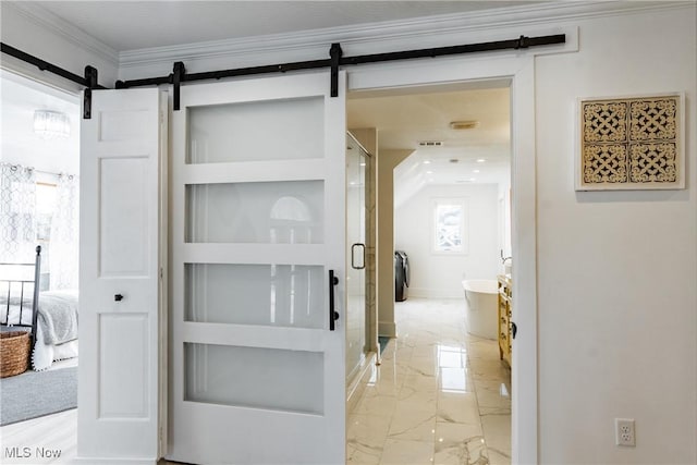 interior space with a barn door and ornamental molding