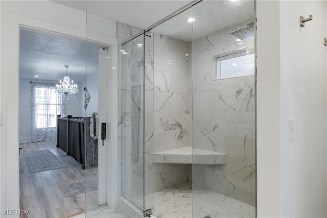 bathroom with an inviting chandelier and an enclosed shower