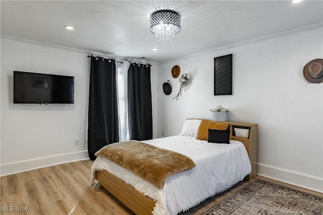 bedroom with a chandelier, hardwood / wood-style floors, and crown molding