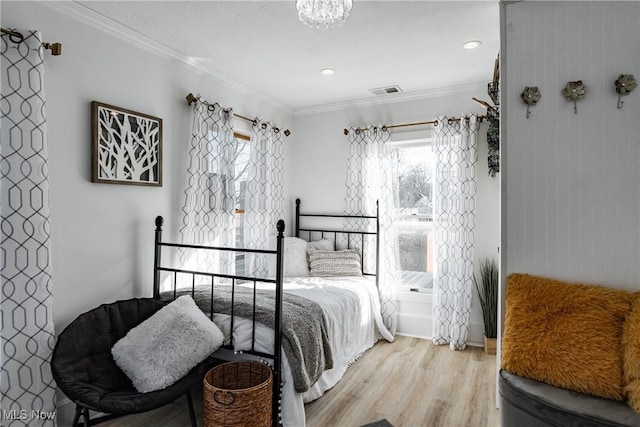 bedroom with light wood-type flooring and crown molding