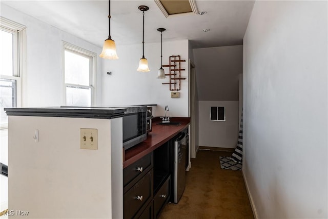 kitchen featuring carpet flooring, dark brown cabinetry, sink, beverage cooler, and pendant lighting