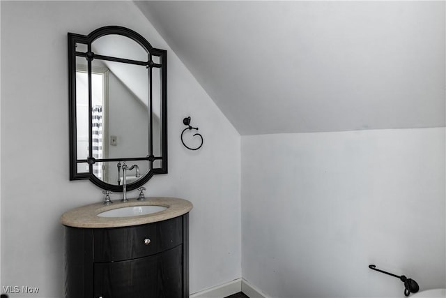 bathroom with vanity and vaulted ceiling