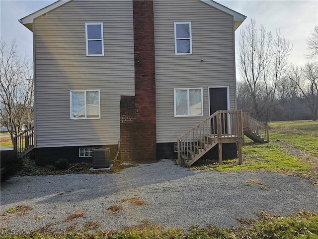 rear view of house featuring central air condition unit