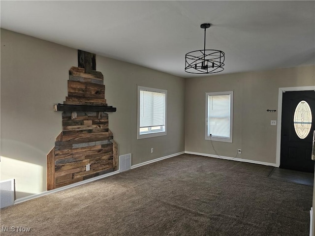 unfurnished living room with dark carpet and an inviting chandelier