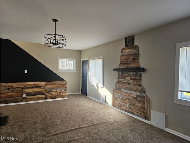 unfurnished living room featuring carpet and a notable chandelier