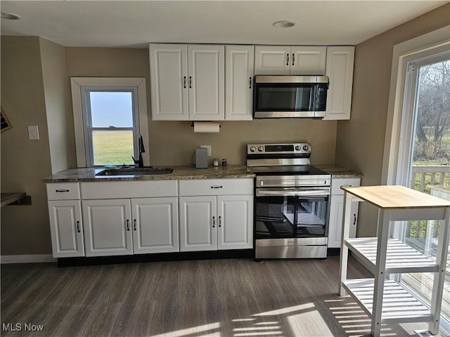 kitchen with white cabinets, dark hardwood / wood-style flooring, sink, and appliances with stainless steel finishes