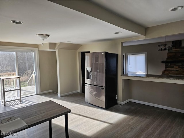 kitchen with hardwood / wood-style floors, stainless steel refrigerator with ice dispenser, and an inviting chandelier