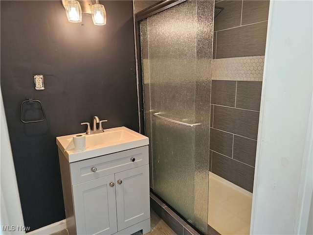 bathroom featuring vanity and a shower with door