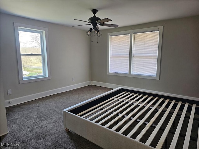 unfurnished bedroom featuring ceiling fan and dark carpet