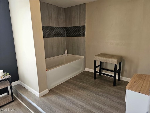 bathroom featuring wood-type flooring and a tub