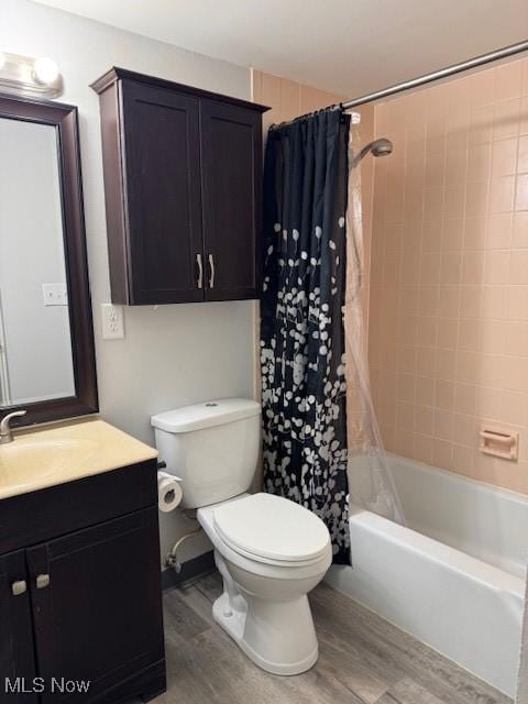 full bathroom featuring toilet, hardwood / wood-style floors, vanity, and shower / tub combo with curtain