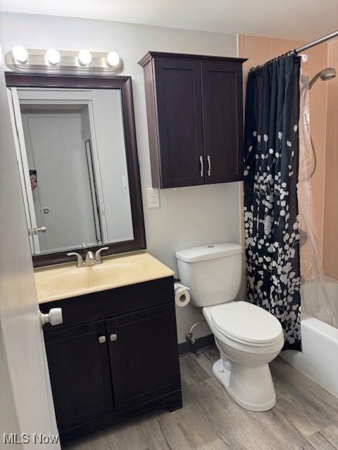 full bathroom with wood-type flooring, vanity, toilet, and shower / bath combo with shower curtain