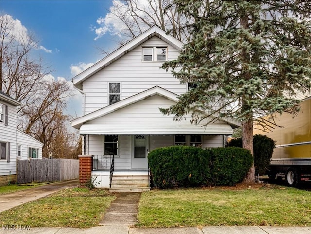 bungalow featuring covered porch and a front yard