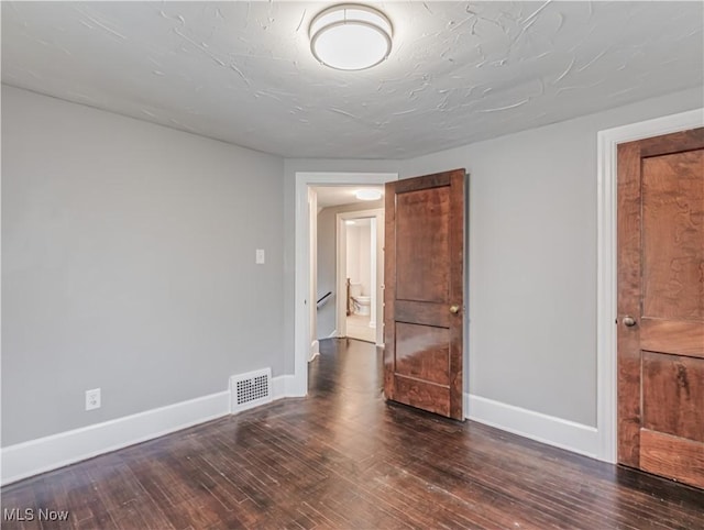 spare room with dark wood-type flooring