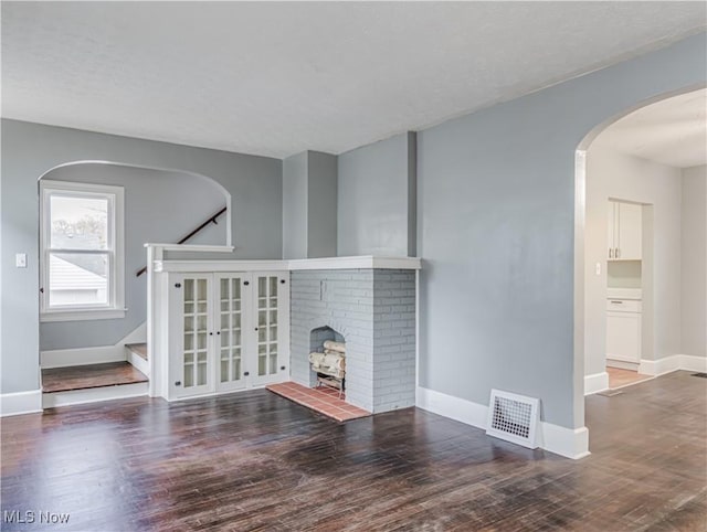 unfurnished living room featuring dark hardwood / wood-style flooring and a fireplace