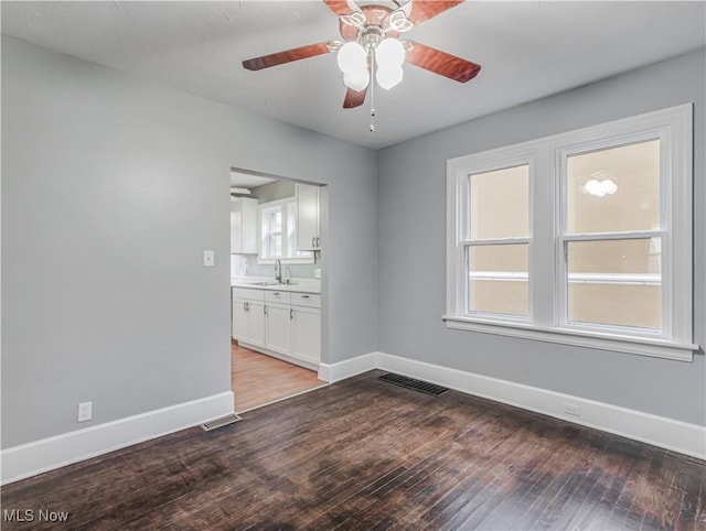 spare room featuring ceiling fan, sink, and hardwood / wood-style flooring