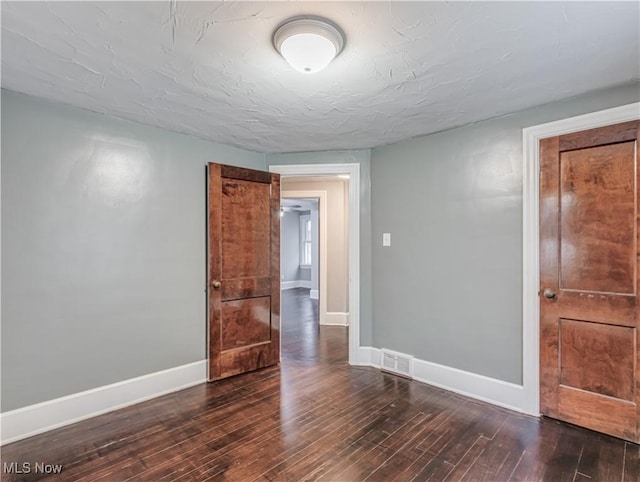 empty room featuring dark hardwood / wood-style flooring