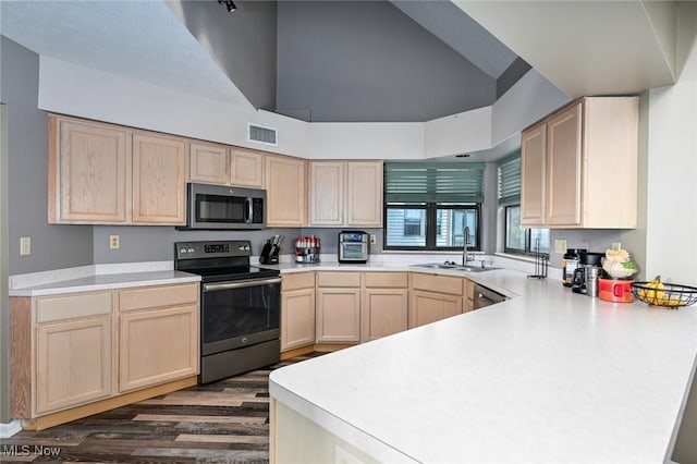 kitchen featuring kitchen peninsula, dark hardwood / wood-style flooring, stainless steel appliances, sink, and light brown cabinets