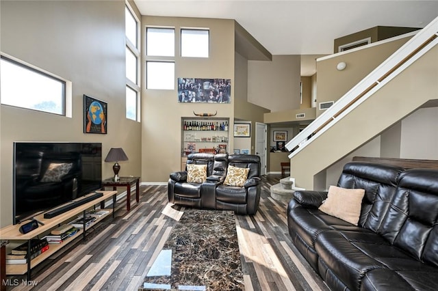 living room featuring hardwood / wood-style flooring and a towering ceiling