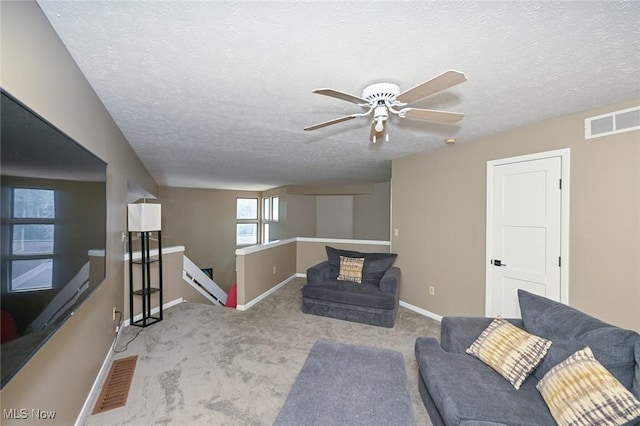 living room with ceiling fan, light colored carpet, a textured ceiling, and a baseboard radiator