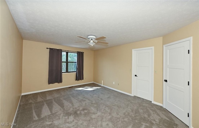 carpeted empty room featuring a textured ceiling and ceiling fan