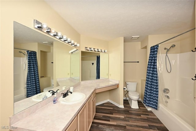 full bathroom with hardwood / wood-style floors, vanity, shower / bath combination with curtain, and a textured ceiling