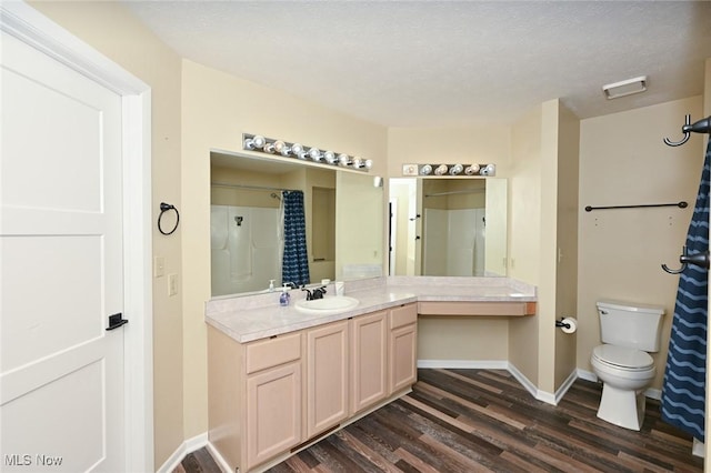 bathroom with a shower with curtain, vanity, hardwood / wood-style flooring, and toilet