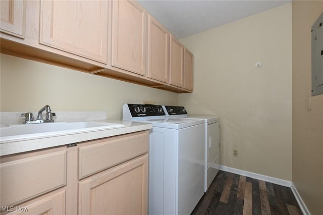 clothes washing area with sink, washer and dryer, cabinets, and dark wood-type flooring