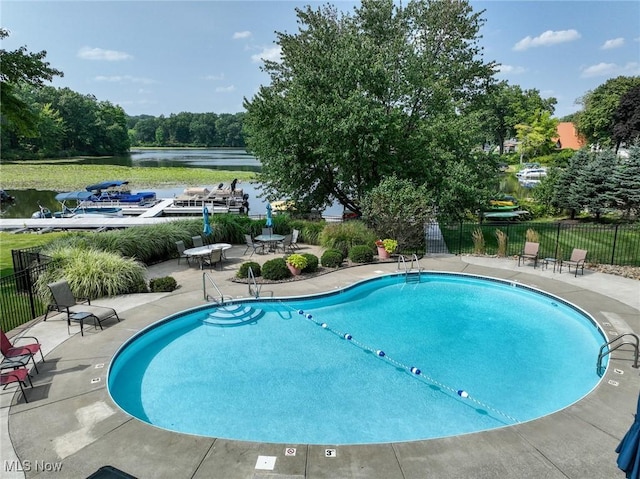 view of pool featuring a patio and a water view