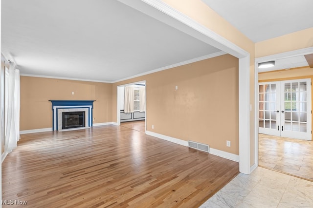 unfurnished living room featuring french doors, visible vents, light wood-style flooring, a glass covered fireplace, and baseboards