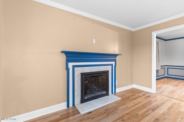 room details featuring baseboards, ornamental molding, wood finished floors, and a glass covered fireplace