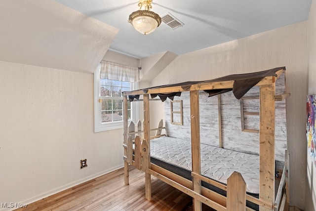 bedroom featuring wood finished floors, visible vents, and baseboards