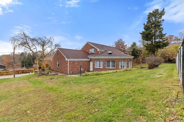 view of front of house featuring brick siding and a front yard