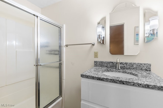 bathroom featuring vanity and enclosed tub / shower combo