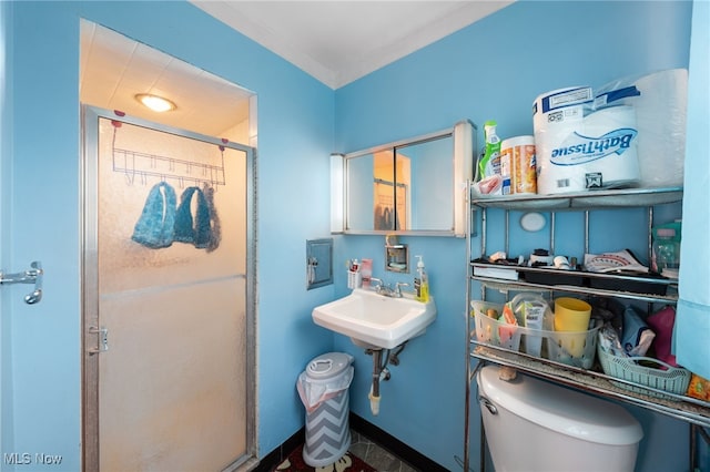 bathroom featuring toilet, an enclosed shower, and crown molding