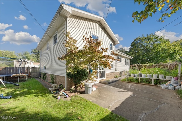 view of home's exterior featuring a yard, a patio, and a trampoline