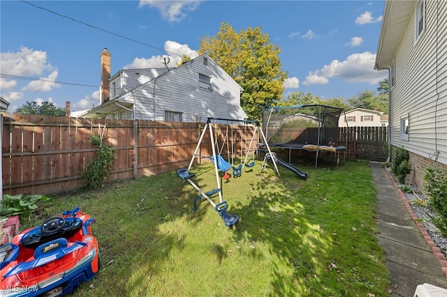 view of yard with a playground and a trampoline