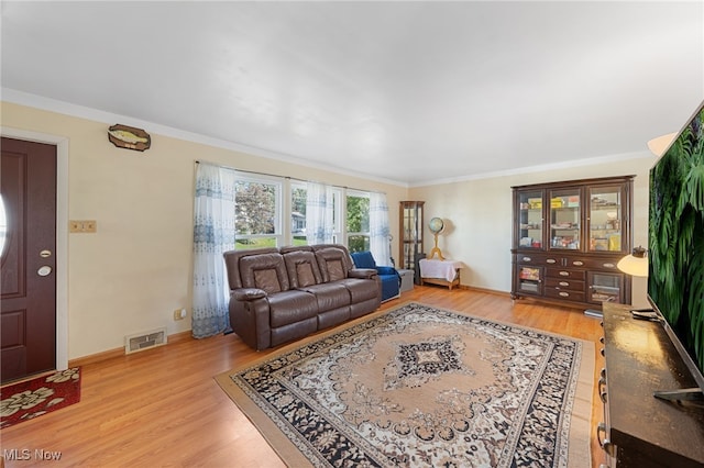 living room with light wood-type flooring and ornamental molding