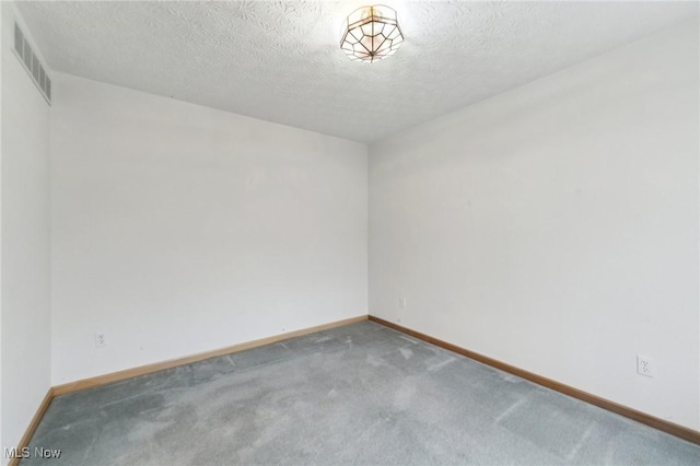 unfurnished room featuring carpet and a textured ceiling