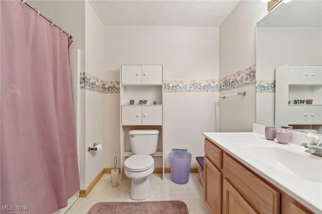 bathroom featuring vanity, toilet, and a textured ceiling