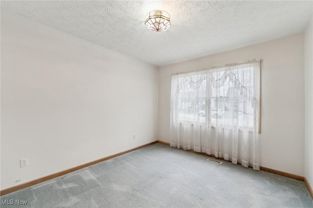 unfurnished room featuring carpet floors and a textured ceiling