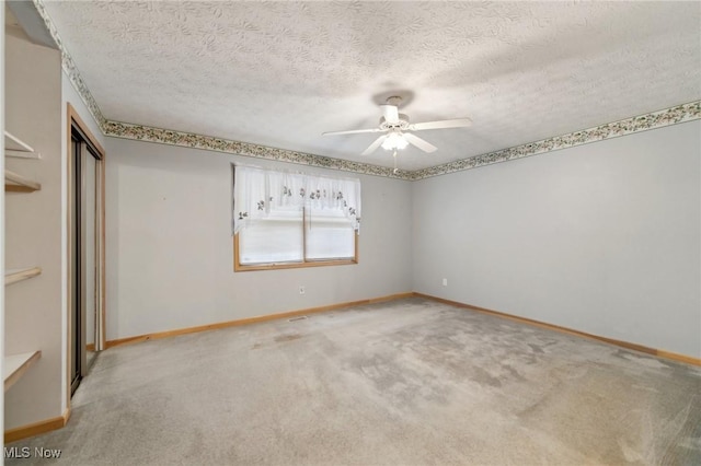 unfurnished bedroom featuring a textured ceiling, a closet, ceiling fan, and light colored carpet