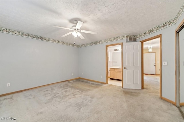 unfurnished bedroom featuring connected bathroom, ceiling fan, light colored carpet, and a textured ceiling