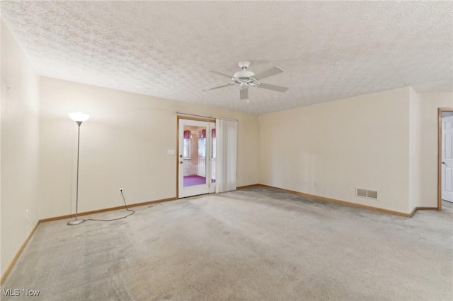 carpeted spare room with ceiling fan and a textured ceiling