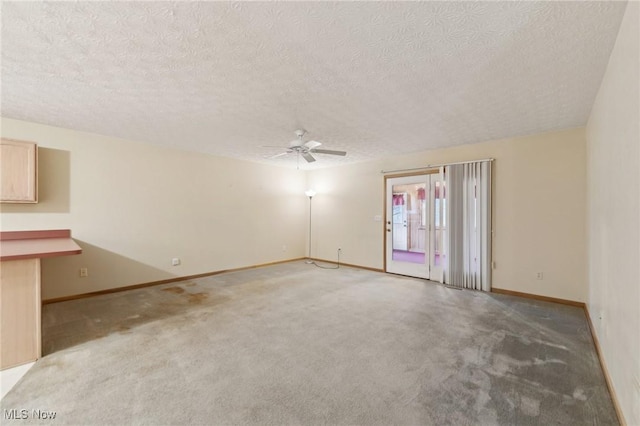 carpeted spare room featuring ceiling fan and a textured ceiling